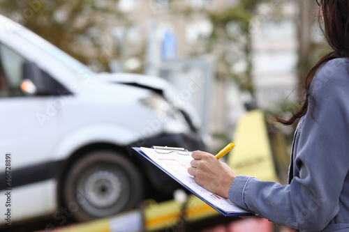 Photos Insurance agent fills out paperwork after accident