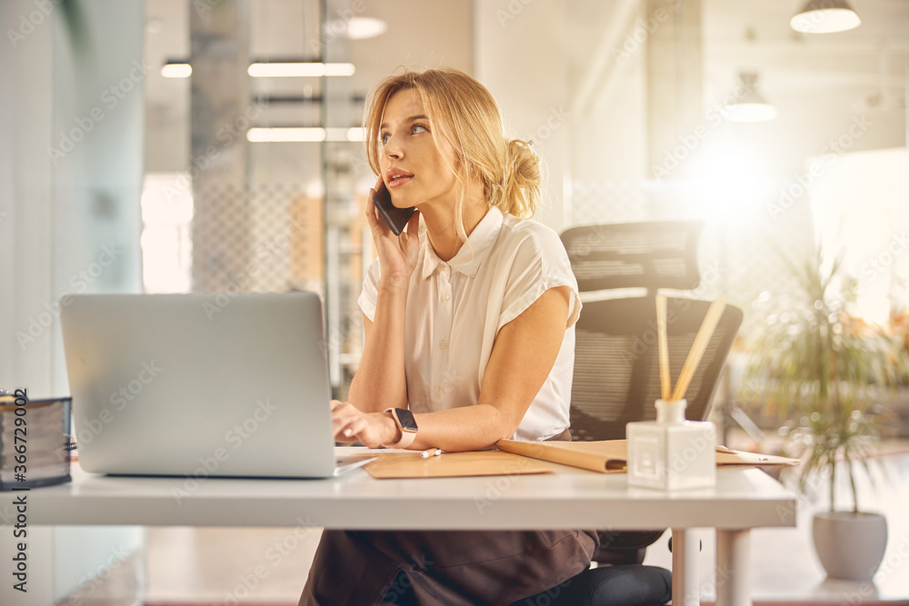 Beautiful businesswoman talking on cellphone at work Beautiful businesswoman talking on cellphone at work
