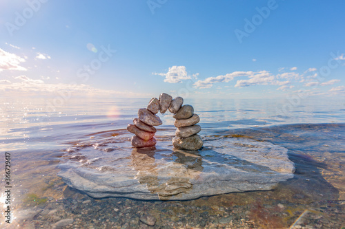 Steinbogen aus Kieselsteinen im Wasser