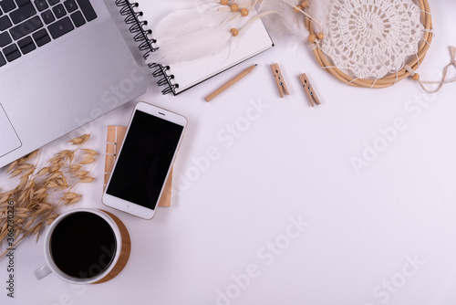 Coffee cup and notebook on white background. with copy space. Office desk with laptop and phone with blank screen. Wooden accessories for work. Top view. 