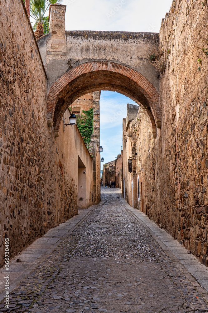 Narrow alley with old stone buildings at Caceres, Extremadura, Spain.