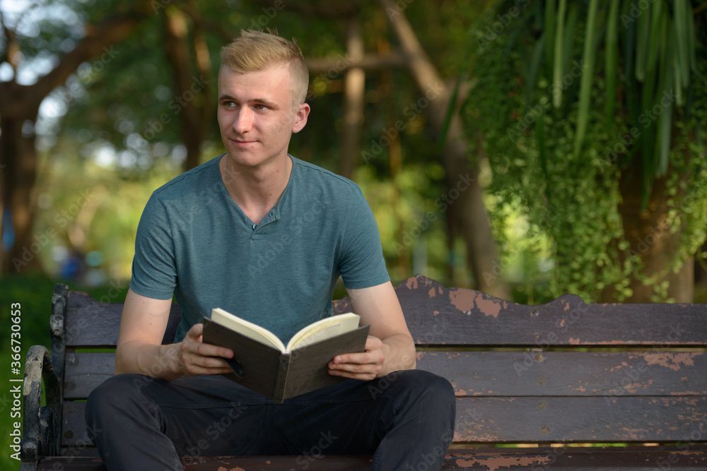 Fototapeta premium Young man with blond hair at the park outdoors