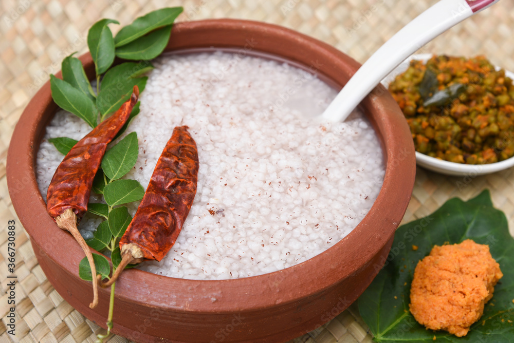 Rice porridge, Kanji, gruel in clay pot palm mat background Kerala