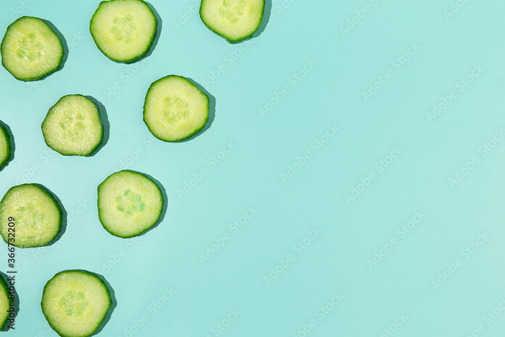 Cut cucumber border frame on abstract pastel cyan background with copy space Cut cucumber border frame on abstract pastel cyan background with copy space