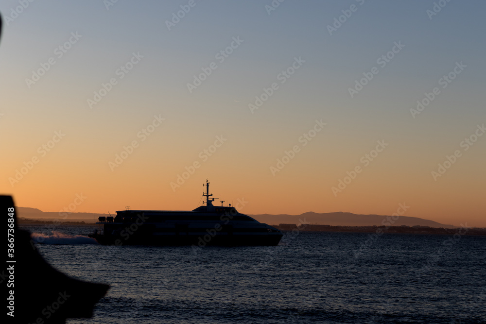 Abstract Ferryboat golden hour during sun rise with sunlight. Perfect silhouette with city lines and ferry boat. Lisbon.
