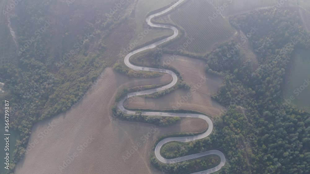 Aerial top down view on a mountain road with hairpin curves, hills and trees Aerial top down view on a mountain road with hairpin curves, hills and trees