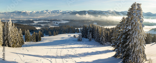 Amazing Panorama View from Snow Mountain with Forest to snowy and foggy Mountain Range. Mountain Hut Klings Huette on Hauchenberg near Diepolz in Allgau, Bavaria, Germany. photo