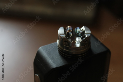 Vaping device with dual coil close up shot. Hi end rebuildable dripping atomizer. Nicotine addiction. photo