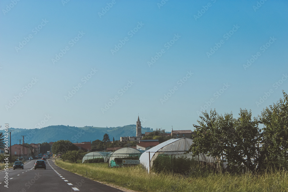 Fototapeta premium old Church in a European village, greenhouses, a village along the highway