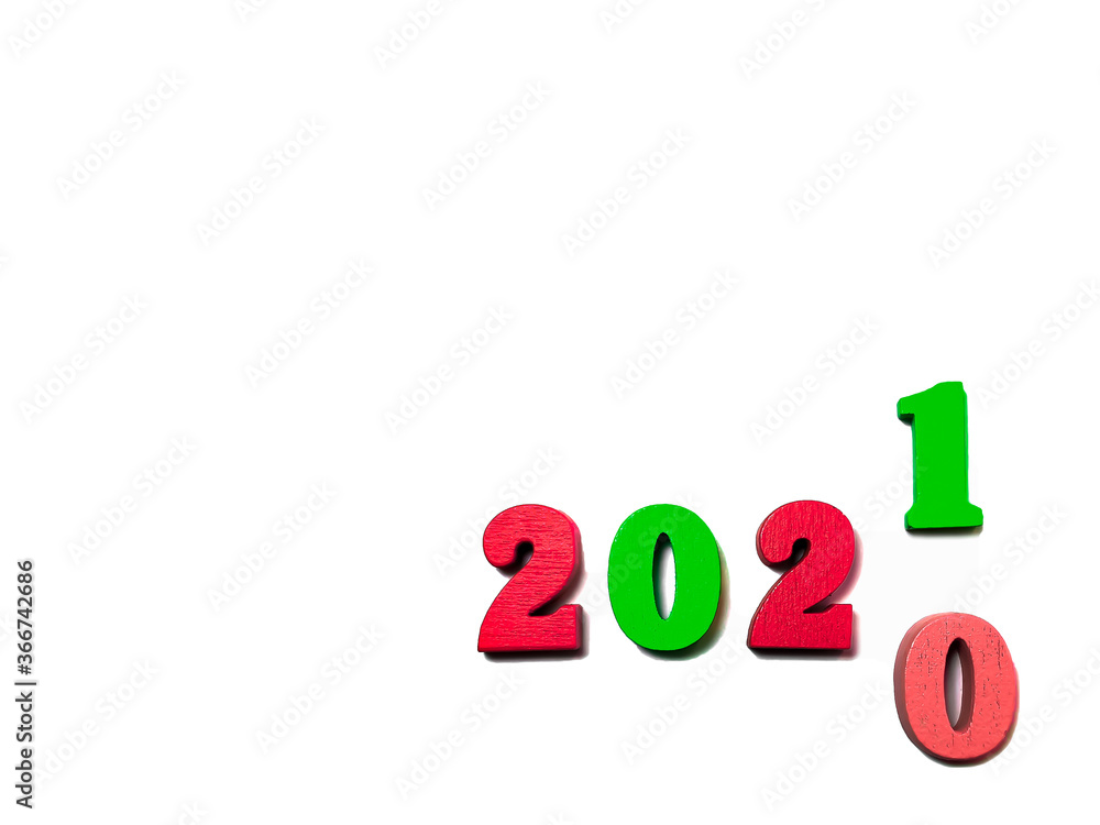 Changes the year 2020 to 2021. Red and green wooden numbers on white background. New year and holiday concept, Christmas colors. Blank for design, space for text Changes the year 2020 to 2021. Red and green wooden numbers on white background. New year and holiday concept, Christmas colors. Blank for design, space for text