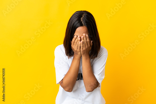 Young volunteer woman isolated on yellow background with tired and sick expression © luismolinero