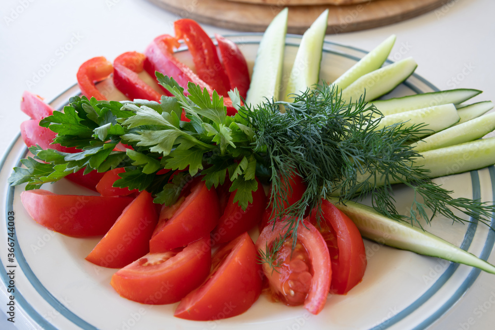 a plate of fresh vegetables - tomato and cucumber a plate of fresh vegetables - tomato and cucumber