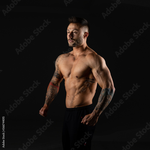Strong man. Bodybuilder on black background.