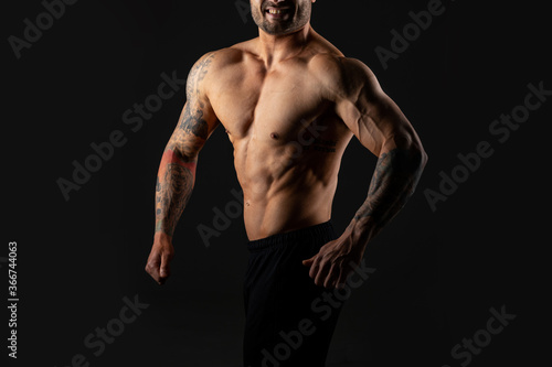 Close up body strong man. Bodybuilder on black background.