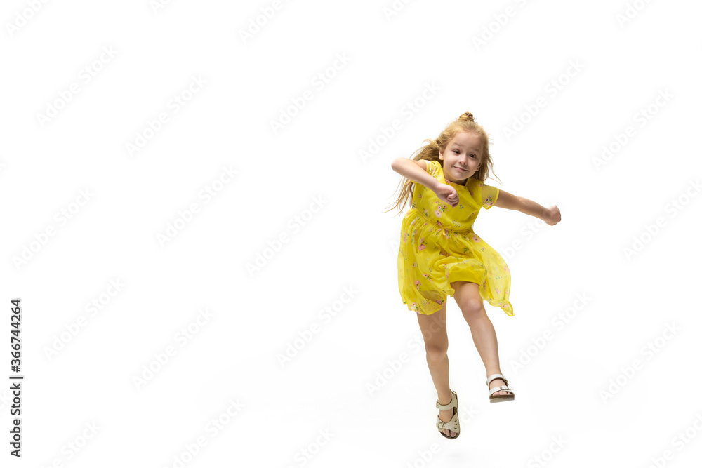 Happy child, little and emotional caucasian girl jumping and running isolated on white background. Looks happy, cheerful, sincere. Copyspace for ad. Childhood, education, happiness concept. Happy child, little and emotional caucasian girl jumping and running isolated on white background. Looks happy, cheerful, sincere. Copyspace for ad. Childhood, education, happiness concept.
