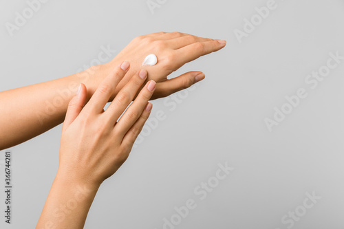 close up beauty shot of tender young woman hands applying moisturizer cold season skin protective cream