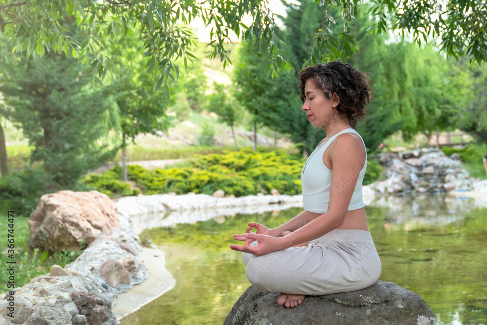 Healthy Lifestyle and Yoga Concept. Close-up hands. Woman do yoga outdoors at sunrise in lotus position. Woman exercising and meditating in morning. Namaste. Healthy Lifestyle and Yoga Concept. Close-up hands. Woman do yoga outdoors at sunrise in lotus position. Woman exercising and meditating in morning. Namaste.