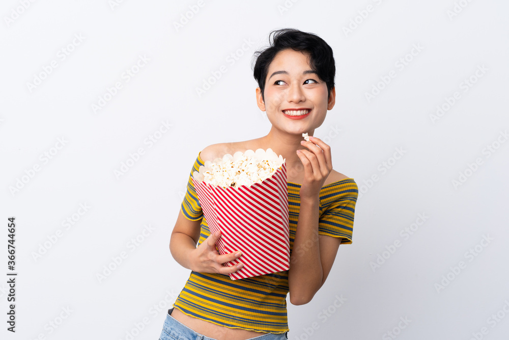 Young Asian girl holding a big bucket of popcorns Young Asian girl holding a big bucket of popcorns