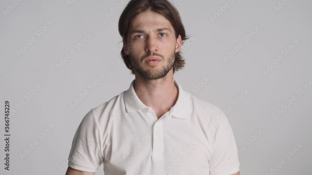 Young serious man emotionally waving no and go away gesture on camera over white background. Get out expression Young serious man emotionally waving no and go away gesture on camera over white background. Get out expression