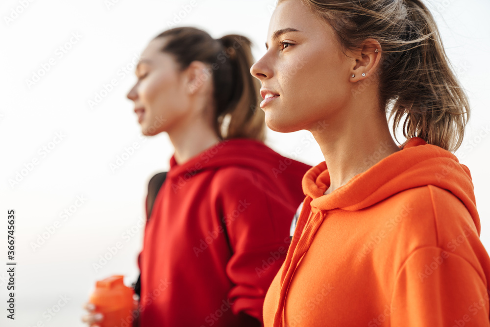Gorgeous girls friends walking outdoors looking aside. Gorgeous girls friends walking outdoors looking aside.