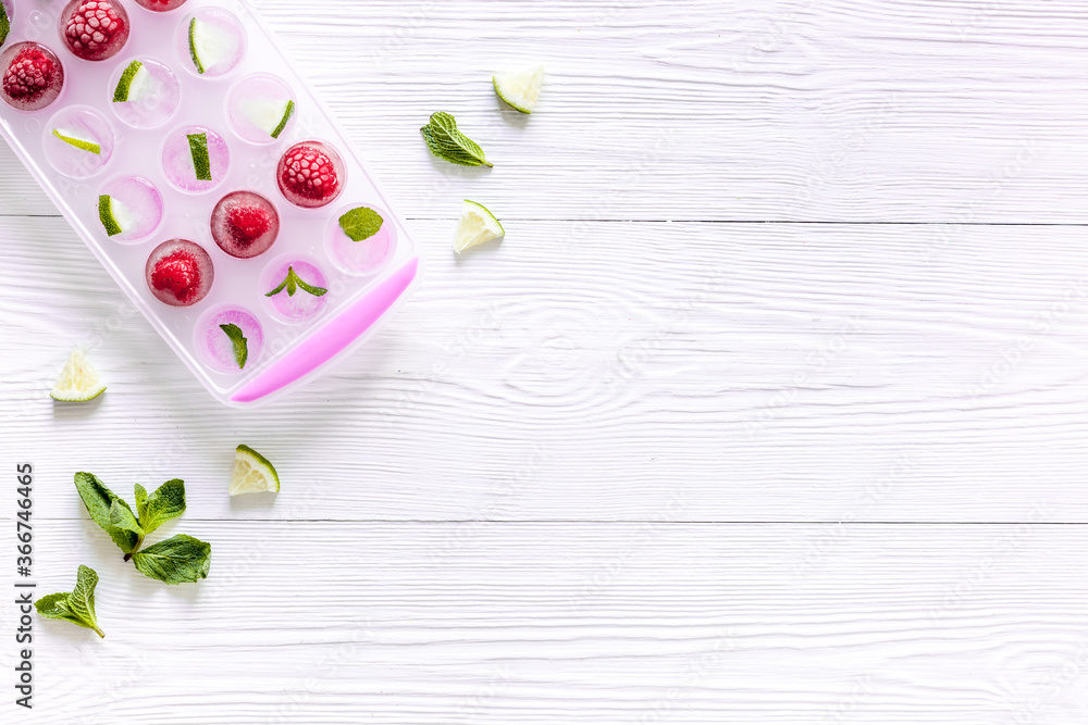 Ice tray with berries, lime and mint on white background top view copy space Ice tray with berries, lime and mint on white background top view copy space