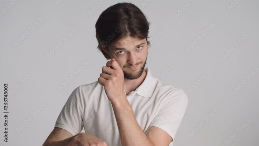 Attractive brunette man confidently alludes on time to pay money over gray background. Time is money expression Attractive brunette man confidently alludes on time to pay money over gray background. Time is money expression