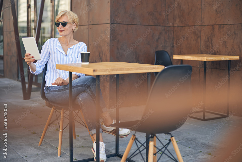 Woman with a gadget sitting in a cafe Woman with a gadget sitting in a cafe
