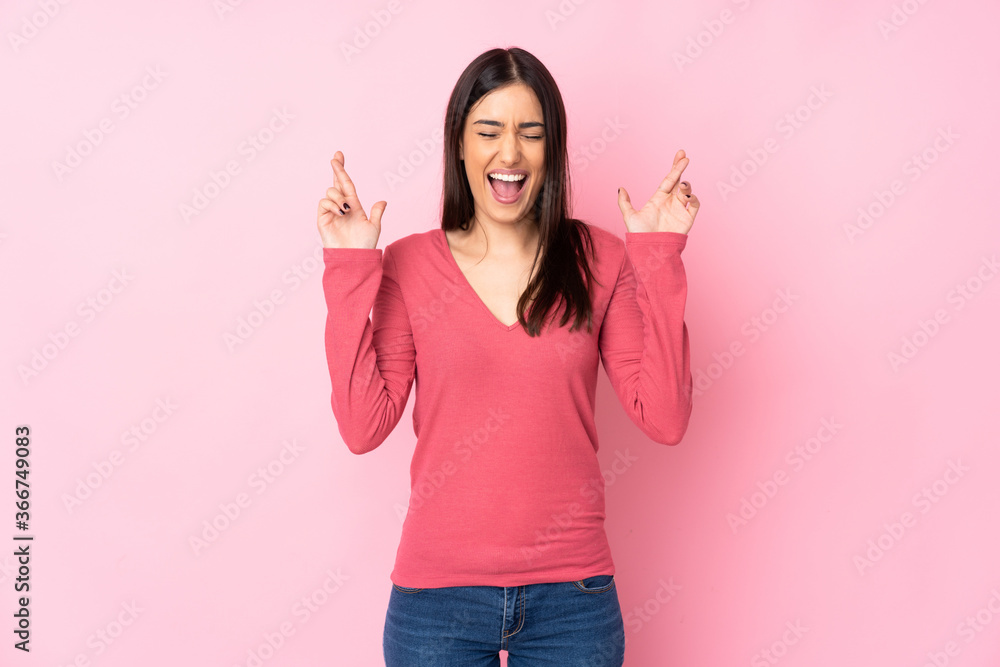 Young caucasian woman over isolated background with fingers crossing Young caucasian woman over isolated background with fingers crossing