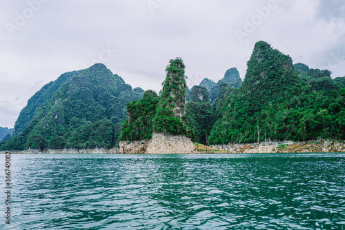 Beautiful view of Limenstone rocks at Cheow Lan lake in background, Ratchaprapha Dam, Khao Sok National Park in Thailand.