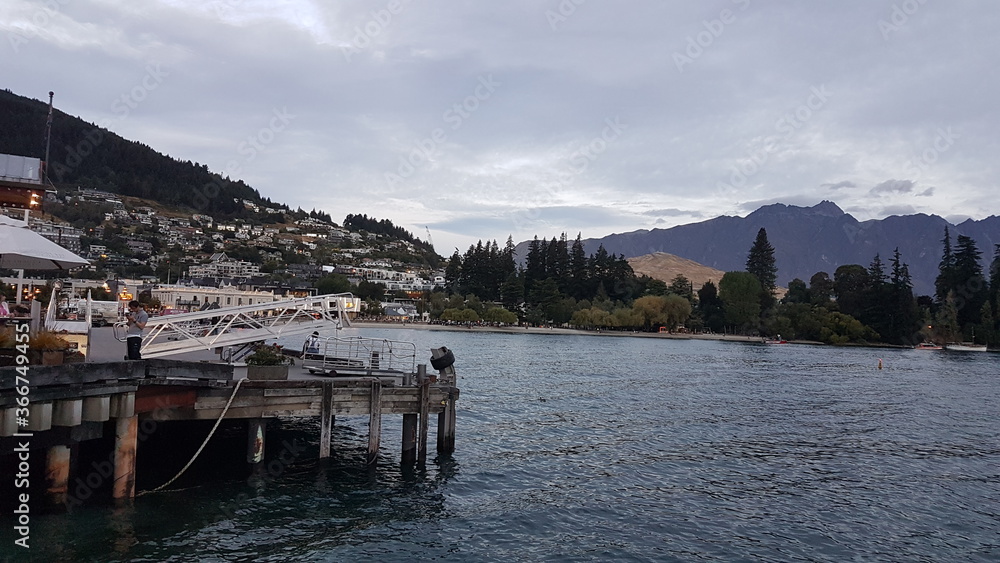 Lake Wakatipu with mountain view, town view, harbor view port view, pier view, sunset and clouds in summer, located in the southwest corner of the Otago region, in the South Island of New Zealand