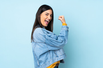 Young caucasian woman isolated on blue background celebrating a victory