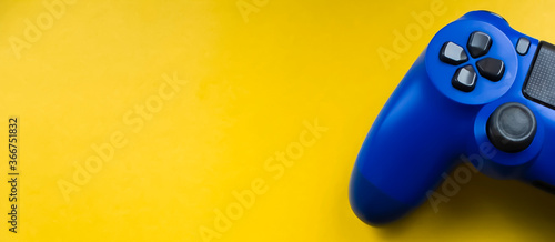 Blue gamepad on a bright yellow background. Banner photo