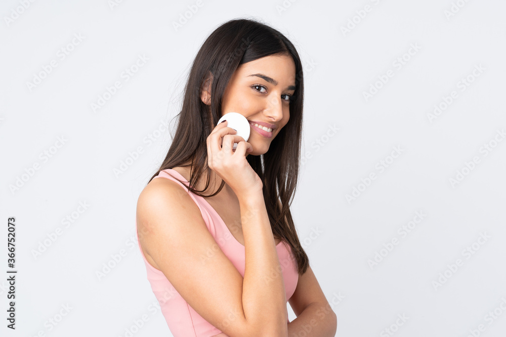 Young caucasian woman isolated on white background with cotton pad for removing makeup from her face Young caucasian woman isolated on white background with cotton pad for removing makeup from her face