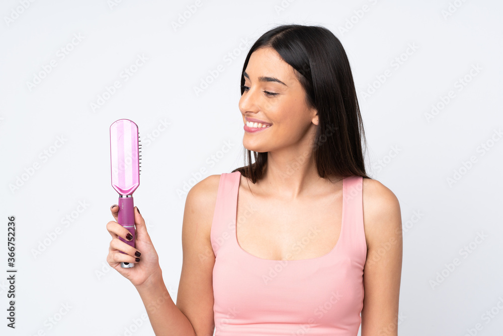 Young caucasian woman isolated on white background with hair comb Young caucasian woman isolated on white background with hair comb