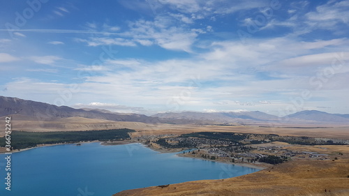 lake Tekapo with mountains view, blue sky and white clouds in summer, with a small town (township) at the southern end of the lake, South Island, New Zealand © filmonearth