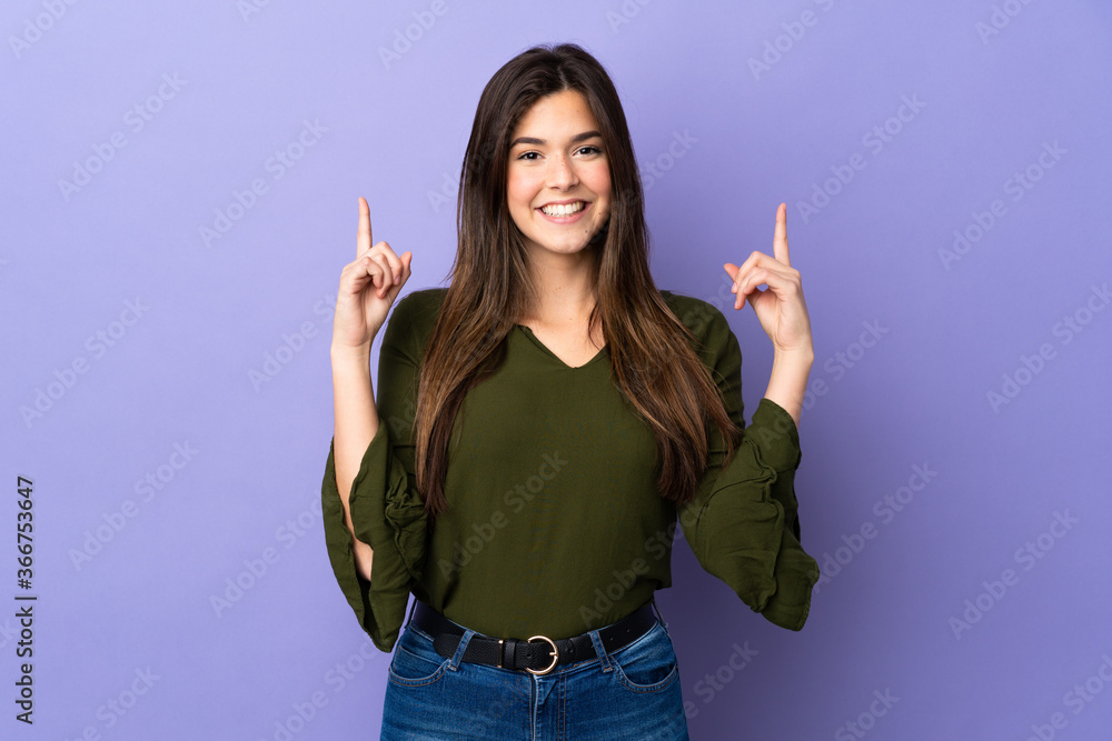 Teenager Brazilian girl over isolated purple background pointing up a great idea Teenager Brazilian girl over isolated purple background pointing up a great idea