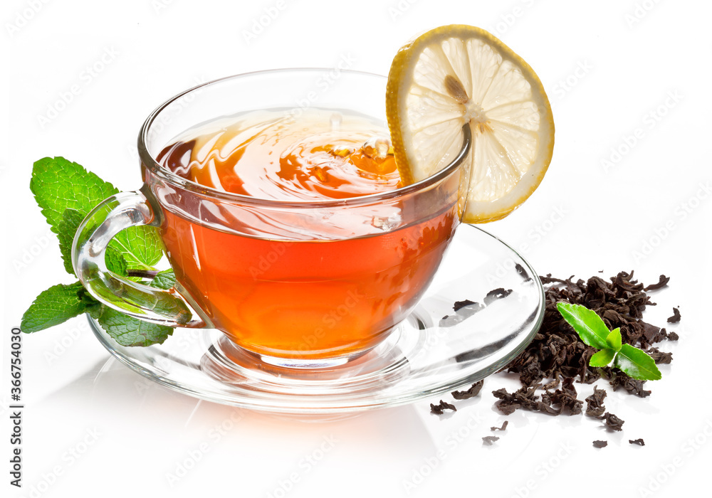 Glass cup with black tea, a slice of lemon and mint leaves isolated on a white background. Glass cup with black tea, a slice of lemon and mint leaves isolated on a white background.