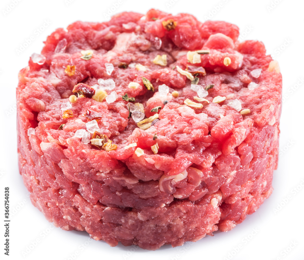 Ground cutlet or raw hamburger with seasonings on white background. Close-up. Ground cutlet or raw hamburger with seasonings on white background. Close-up.