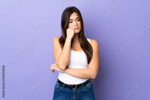 Teenager Brazilian girl over isolated purple background with tired and bored expression