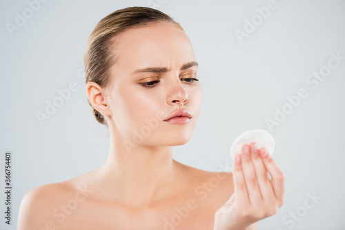 naked young woman looking at cotton pad isolated on grey