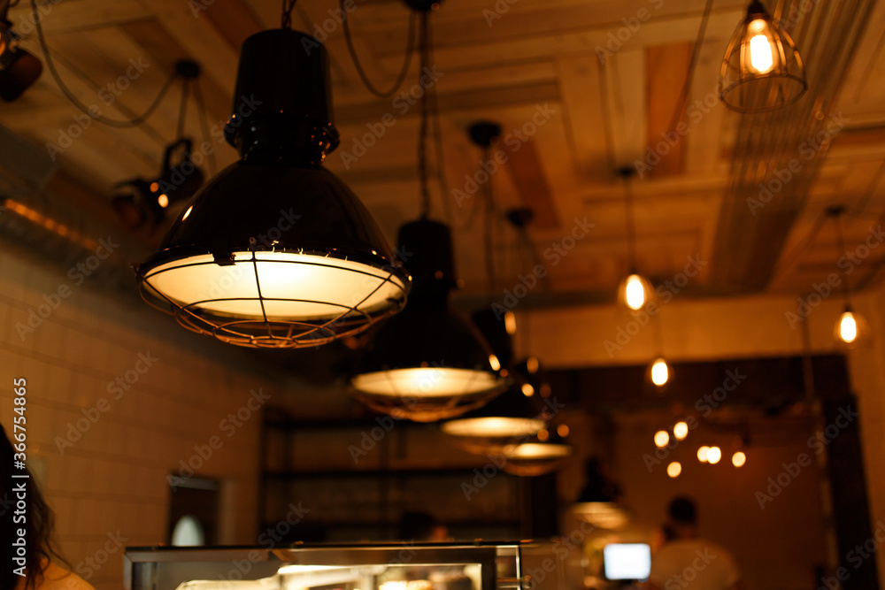 Stylish lighting lamps over a bar counter in a loft hookah bar Stylish lighting lamps over a bar counter in a loft hookah bar