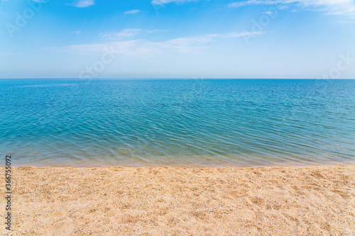 Calm clear blue sea and white sand beach