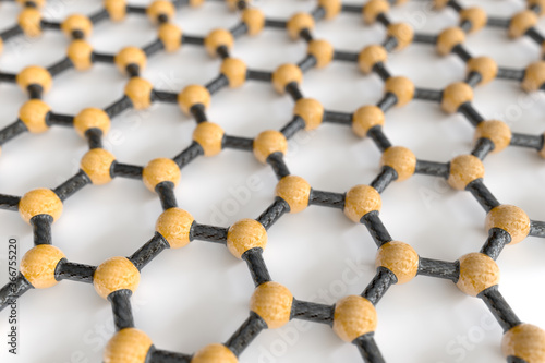 3D rendering of graphene sheet, yellow atoms, grey bonds, white background