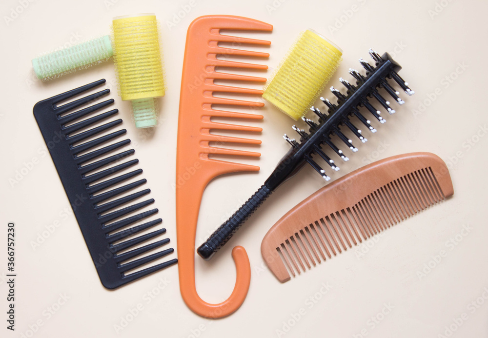 Green yellow curlers, combs, hair brush. Hair care concept. Pastel background. Top view