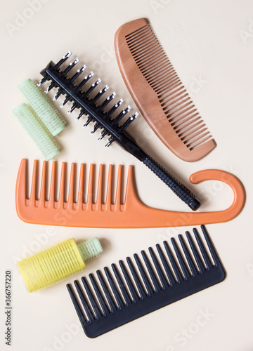 Green yellow curlers, combs, hair brush. Hair care concept. Pastel background. Top view