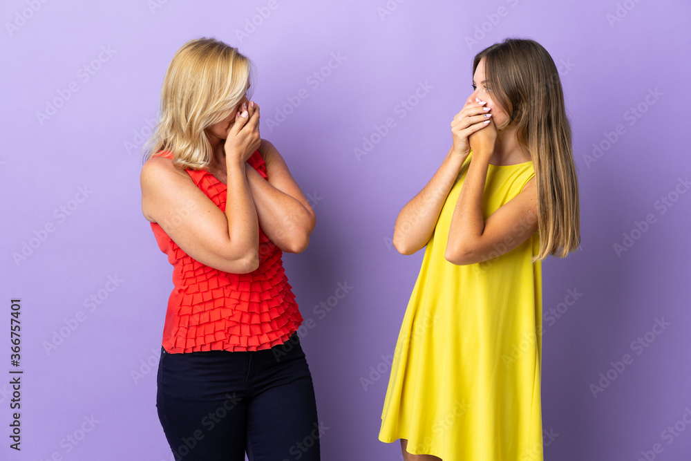 Mom and daughter isolated on purple background covering mouth with hands for saying something inappropriate Mom and daughter isolated on purple background covering mouth with hands for saying something inappropriate