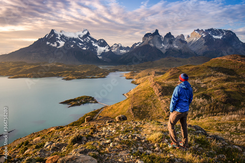 Solo traveler relaxing and meditating in front of the patagonian mountains and lakes. Freedom lifestyle of an hiker immersed in nature. Chile