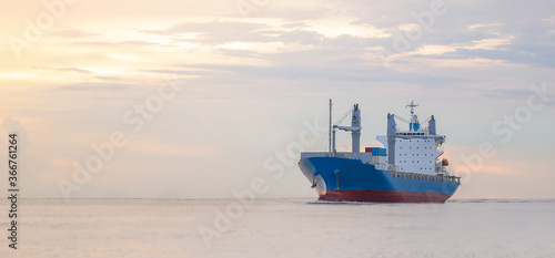 logistics and transportation concept.cargo ship import export commerce sail boat at sea at twilight sky photo