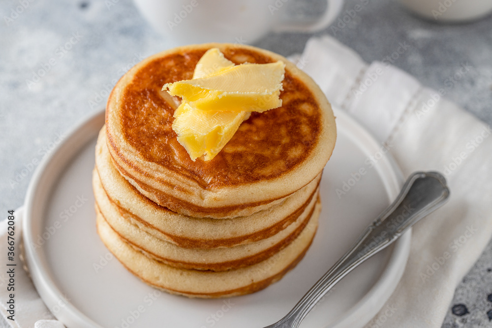 Stack of american pancakes with butter on light concrete background for breakfast.Close up Stack of american pancakes with butter on light concrete background for breakfast.Close up