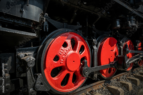 The wheels of the steam train are on the rails